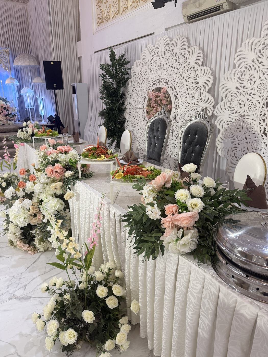 Meja pengantin dihias bunga segar lengkap dengan hidangan katering