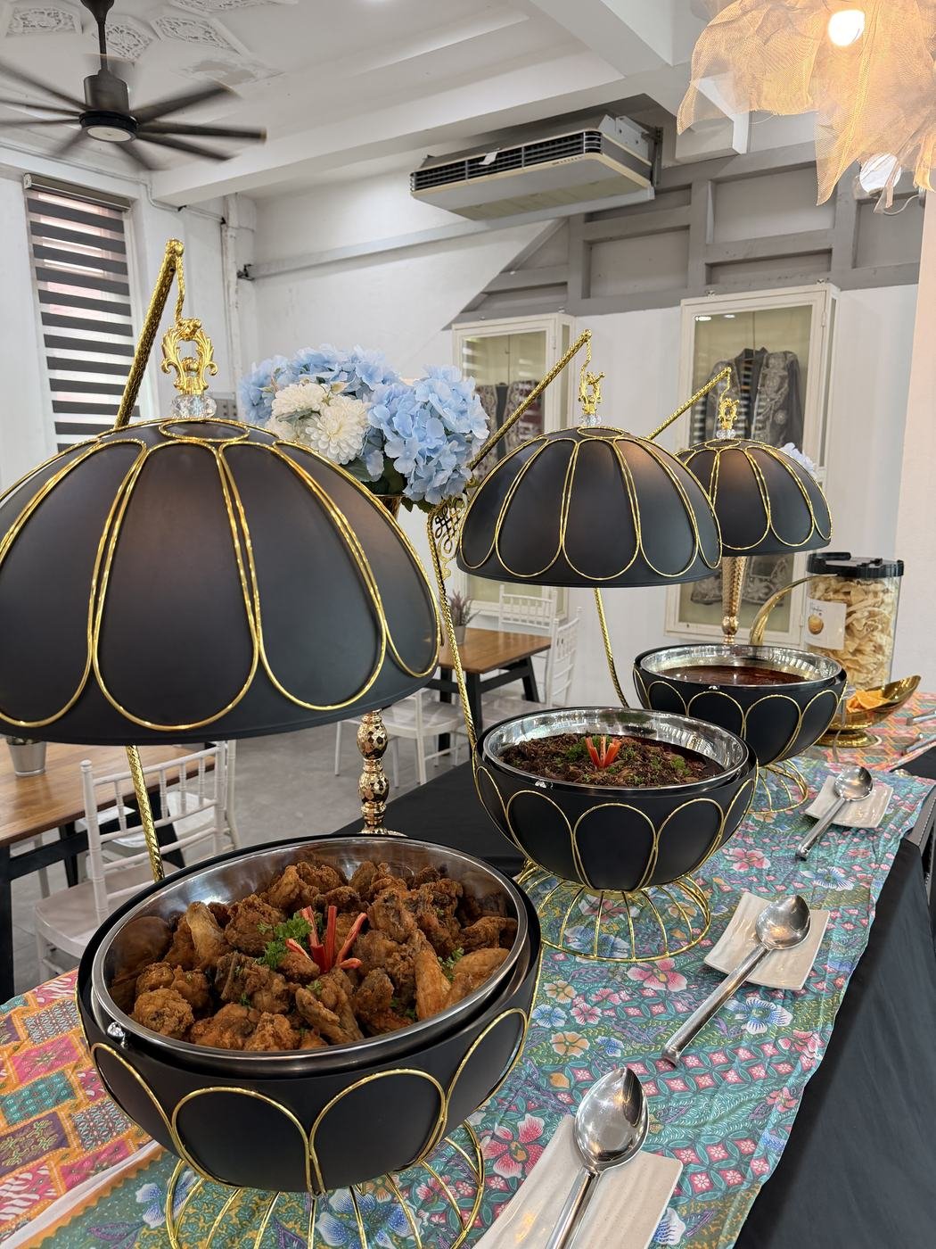 Ayam masak merah dalam bekas saji hitam bercorak emas
